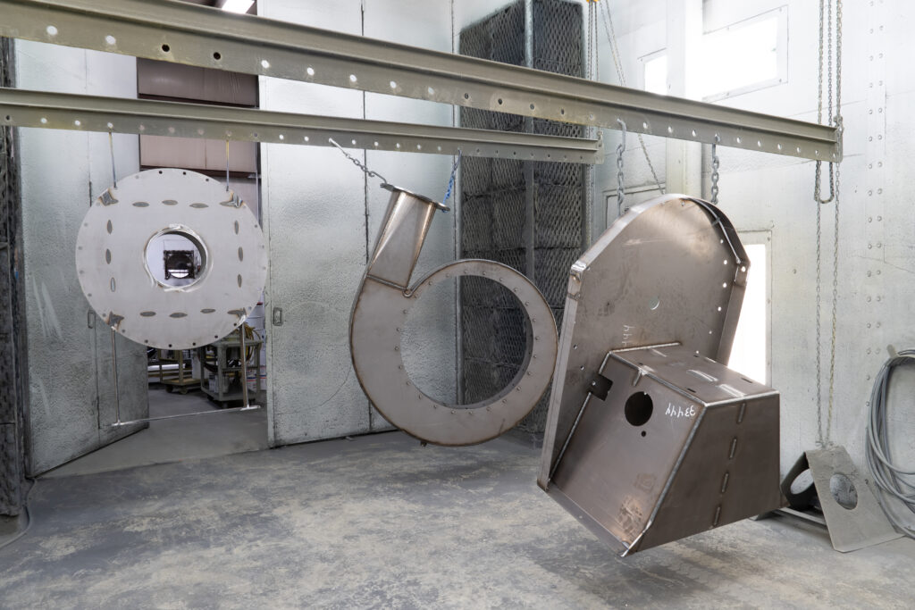 Pressure blower housing hanging in the paint room ready to be primed and painted.